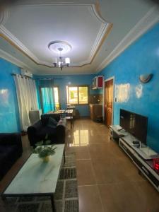 ein Wohnzimmer mit Sofa und Fernseher in der Unterkunft Chez Matis in Pointe-Noire