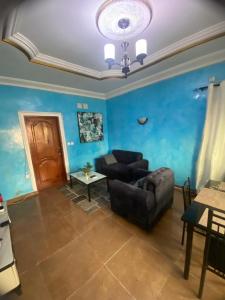 ein Wohnzimmer mit einem Sofa und einer blauen Wand in der Unterkunft Chez Matis in Pointe-Noire