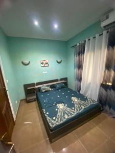 ein Schlafzimmer mit einem Bett in einem Zimmer mit grünen Wänden in der Unterkunft Chez Matis in Pointe-Noire