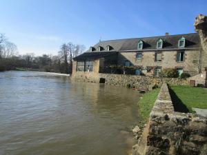 een gebouw aan de oever van een rivier bij Gîte Le Bourgneuf in Fresnay-sur-Sarthe