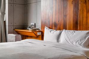 a bedroom with a bed with a wooden headboard and a telephone at CHECK inn Express Taichung Fengchia in Taichung