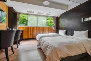a bedroom with two beds and a large window at CHECK inn Express Taichung Fengchia in Taichung
