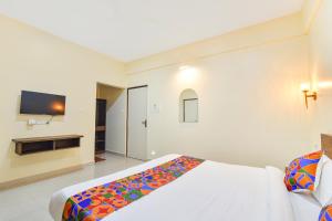 a bedroom with a bed and a flat screen tv at Fabhotel Baga Tulip - 500M From Baga Beach in Baga