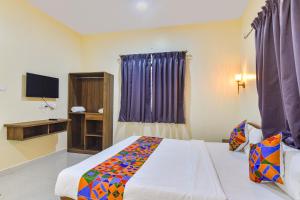 a bedroom with a bed and a television in it at Fabhotel Baga Tulip - 500M From Baga Beach in Baga