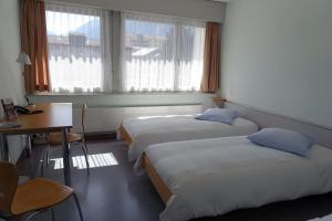 Llit o llits en una habitació de Hôtellerie Franciscaine 37 fotos més