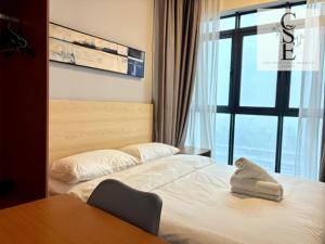 a hotel room with a bed with a chair and a table at Kavenue 2-Bedroom City View by CSE in Donggongon