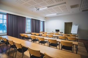an empty lecture room with tables and chairs at Hyvärilä Youth- and Holiday Centre in Nurmes