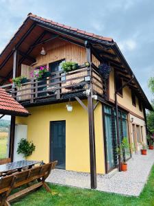 Casa amarilla con balcón y banco en Casa Pescarului JIM, en Cuptoare