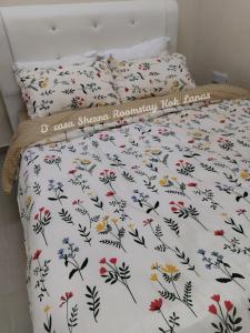 KeterehD'casa Sherra Homestay Kok Lanas的一张带白色棉被和鲜花的床