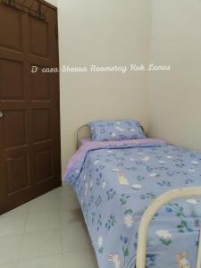 KeterehD'casa Sherra Homestay Kok Lanas的一间小卧室,配有一张带蓝色棉被的床