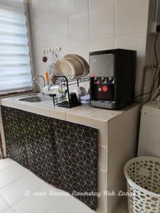 KeterehD'casa Sherra Homestay Kok Lanas的微波炉,放在柜台上,旁边是水槽