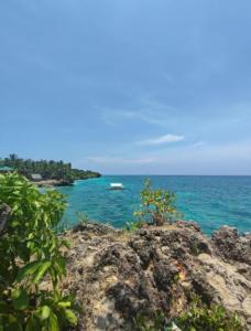 a view of the ocean with a boat in the water at Viva La Rosa Hometel in Anda +29 photos