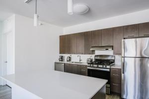 a kitchen with wooden cabinets and a stainless steel refrigerator at Blueground River North pool AC nr park CHI-1193 in Chicago