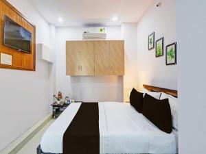 a bedroom with a black and white bed at Super Hotel O Karmanghat Near TKR khaman in Hyderabad