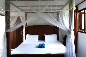 a bed with two blue shoes sitting on it at Bamboo Garden Inn in Goiyapana