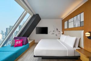 a hotel room with a bed and a large window at Aloft by Marriott Bangkok Sukhumvit 11 in Bangkok