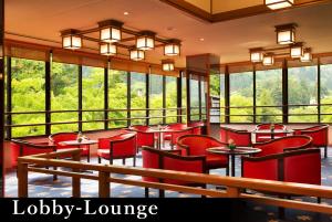 a restaurant with red chairs and tables and windows at Yamanaka Onsen Kagari Kisshotei in Kaga