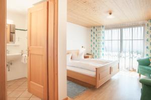 a bedroom with a bed and a large window at Hotel Dreiländerblick Dornbirn in Dornbirn