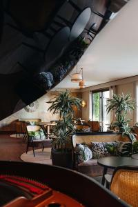 a restaurant with potted plants and tables and chairs at Hyatt Regency Nice Palais de la Méditerranée in Nice