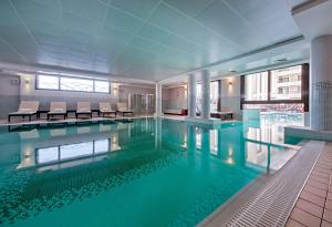 a swimming pool with blue water in a building at Hyatt Regency Nice Palais de la Méditerranée in Nice