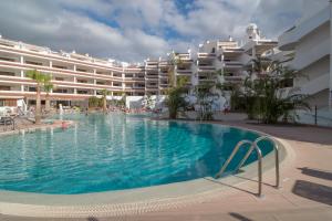 a large swimming pool in front of a hotel at Paloma Beach Apartments in Los Cristianos