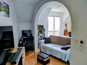 a living room with a couch and a guitar at Appartement Guillestre 2 personnes in Guillestre