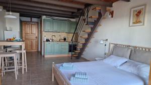 a living room with a bed and a kitchen with a staircase at Sunrise Studio 2 Afitos in Afitos