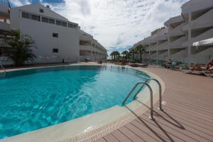 a large swimming pool next to a building at Paloma Beach Apartments in Los Cristianos