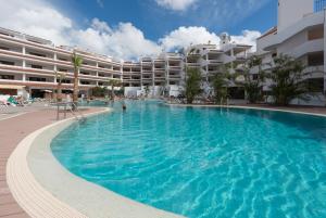 a large swimming pool in front of a hotel at Paloma Beach Apartments in Los Cristianos