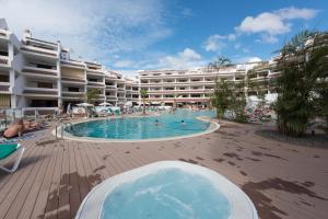 a hotel with a swimming pool in front of a hotel at Paloma Beach Apartments in Los Cristianos
