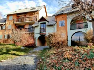 an orange and white house with a driveway at Appartement Guillestre 2 personnes in Guillestre