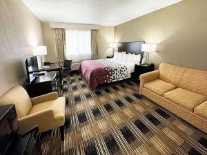 a hotel room with a bed and a desk and chairs at Econo Lodge Wausau - Rothschild in Rothschild