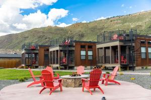 a group of red chairs sitting in front of a house at Ridgeline Hotel at Yellowstone, an Ascend Collection Hotel in Gardiner