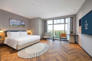 Golden Tulip Qingdao Hongdao Exhibition Center Hotel客房内的一张或多张床位