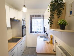 a kitchen with white cabinets and a sink and a window at Modernes Apartment mit Balkon & Parkplatz, WiFi in Bremen