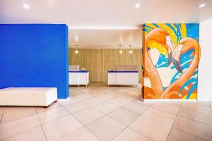 a room with a blue wall and a large painting at TRYP by Wyndham Aruba in Palm-Eagle Beach