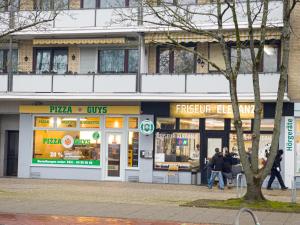 a pizza shop with people walking in front of it at Modernes Apartment mit Balkon & Parkplatz, WiFi in Bremen