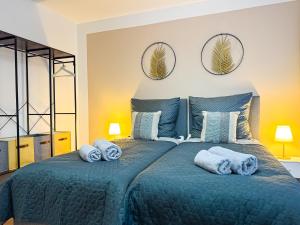 a bedroom with a blue bed with towels on it at Modernes Apartment mit Balkon & Parkplatz, WiFi in Bremen