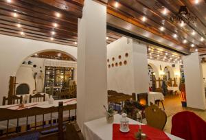 un restaurante con paredes blancas y techos de madera en Kemencés Csárda és Panzió, en Hajdúszoboszló
