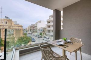 un tavolo e sedie su un balcone con vista su una strada di Grand 3bed Burseley Terrace Fl8 Swieqi By Homely a Is-Swieqi