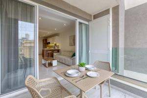 una sala da pranzo con tavolo e sedie e un soggiorno di Grand 3bed Burseley Terrace Fl8 Swieqi By Homely a Is-Swieqi