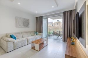 un soggiorno con un divano e un tavolo di Grand 3bed Burseley Terrace Fl8 Swieqi By Homely a Is-Swieqi