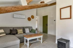 a living room with a couch and a table at L'Euphorbe Terrasse Wifi in Peyriac-de-Mer