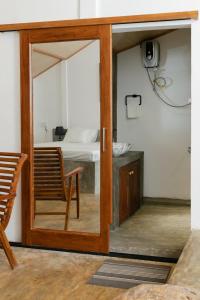 a sliding glass door with a chair in a room at THE LODGE by Eco Love in Galle +23 photos