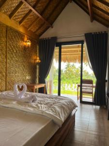 a bedroom with a bed with swans on it at PANORAMA BUNGALOWs in Tetebatu +127 photos