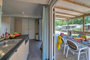 a kitchen with a counter and a table with chairs at Domaine Résidentiel de Plein Air L'Île d'Offard in Saumur