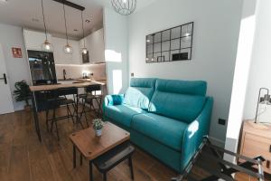 ein Wohnzimmer mit einem blauen Sofa und einem Tisch in der Unterkunft Macarena Suites in Cáceres
