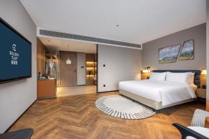 Golden Tulip Qingdao Hongdao Exhibition Center Hotel客房内的一张或多张床位