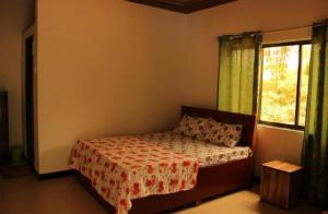 a bedroom with a bed and a window at Neel Garden Home Stays in Adi