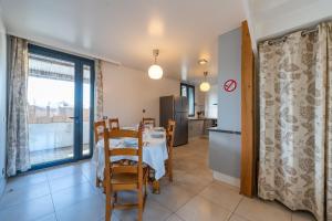 a kitchen and a dining room with a table and chairs at Les Coteaux 2 - 5 chambres proche CDG in Argenteuil +4 photos